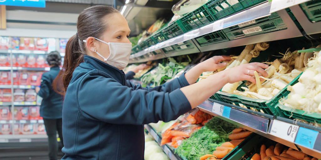 Supermarket worker on vegetable aisle