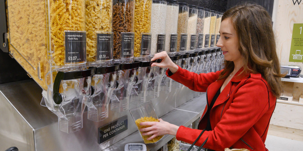 Woman filling up pasta at Waitrose refill section